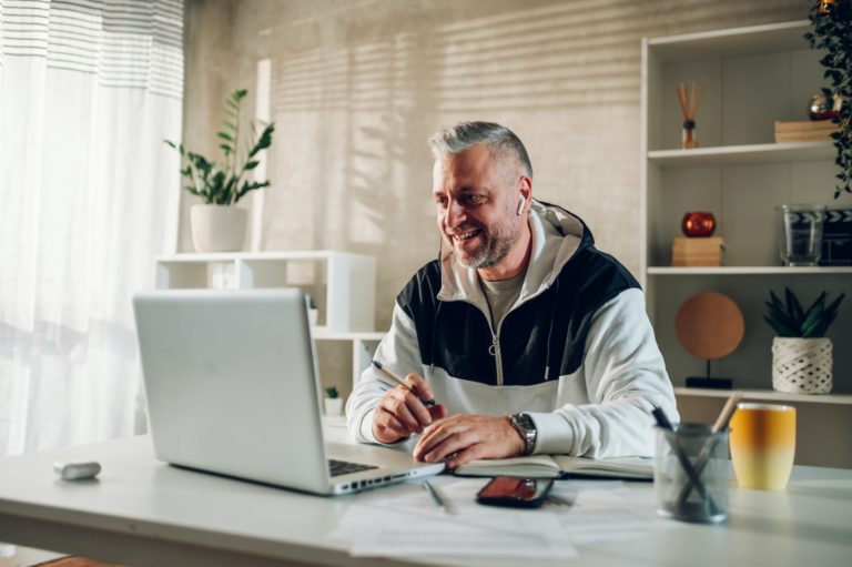 Middle aged man using a laptop while working in a home office