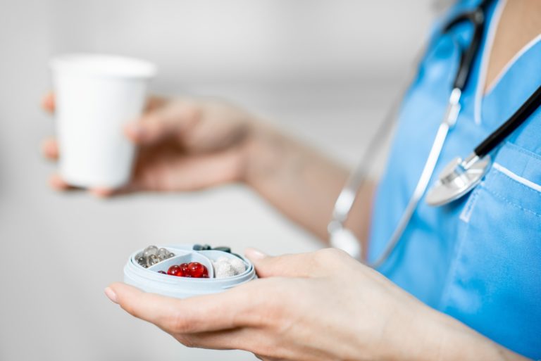 Nurse with pillbox and a cup of water