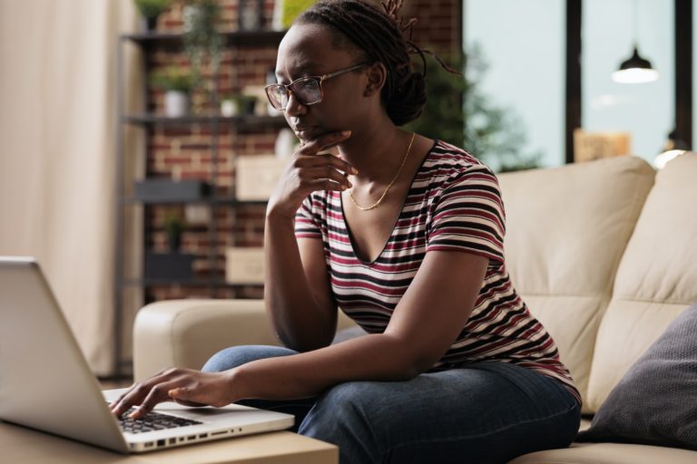 Serious thoughtful freelancer working, looking at laptop