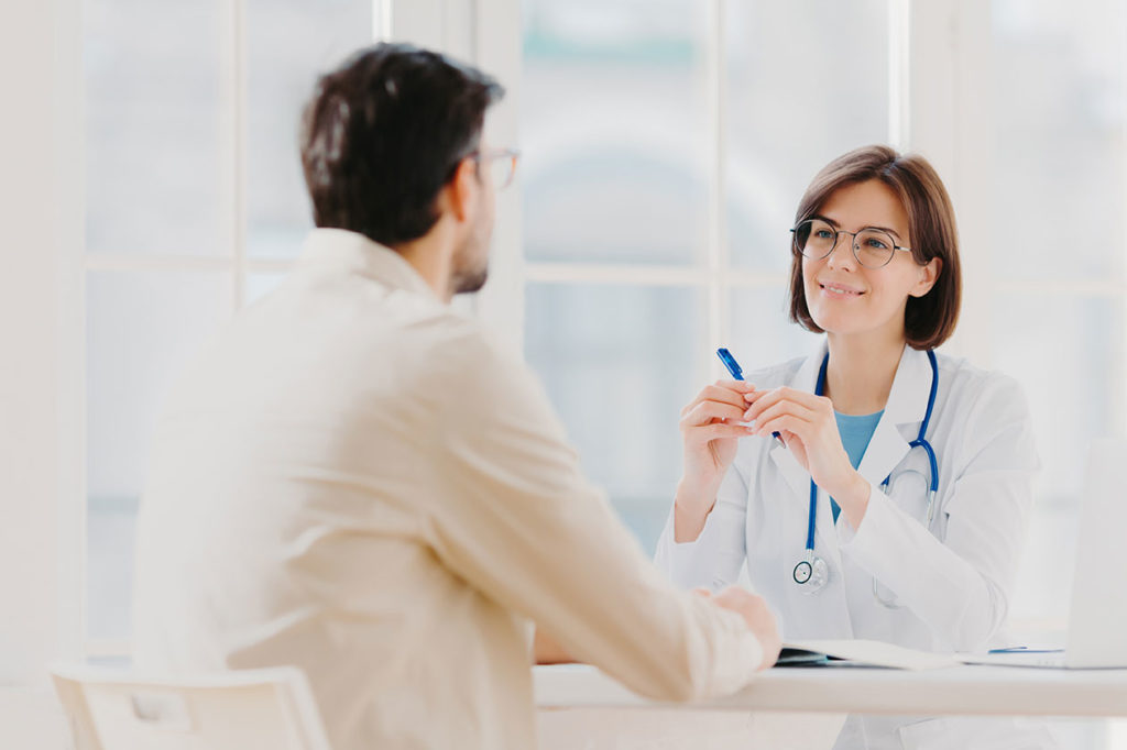 skilled-therapist-in-white-uniform-talks-with-patient